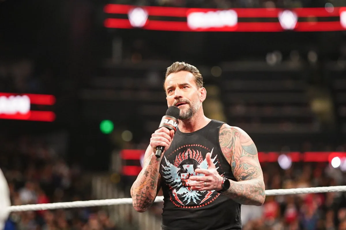 CM Punk confidently walks toward the ring as fans react, symbolizing how CM Punk eyes WrestleMania main event with determination and purpose.